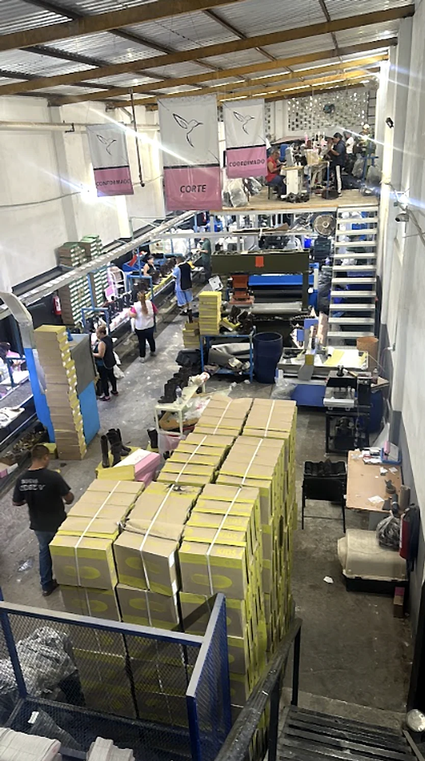 Vista general de la planta: áreas de corte y conformado, con cajas de calzado apiladas